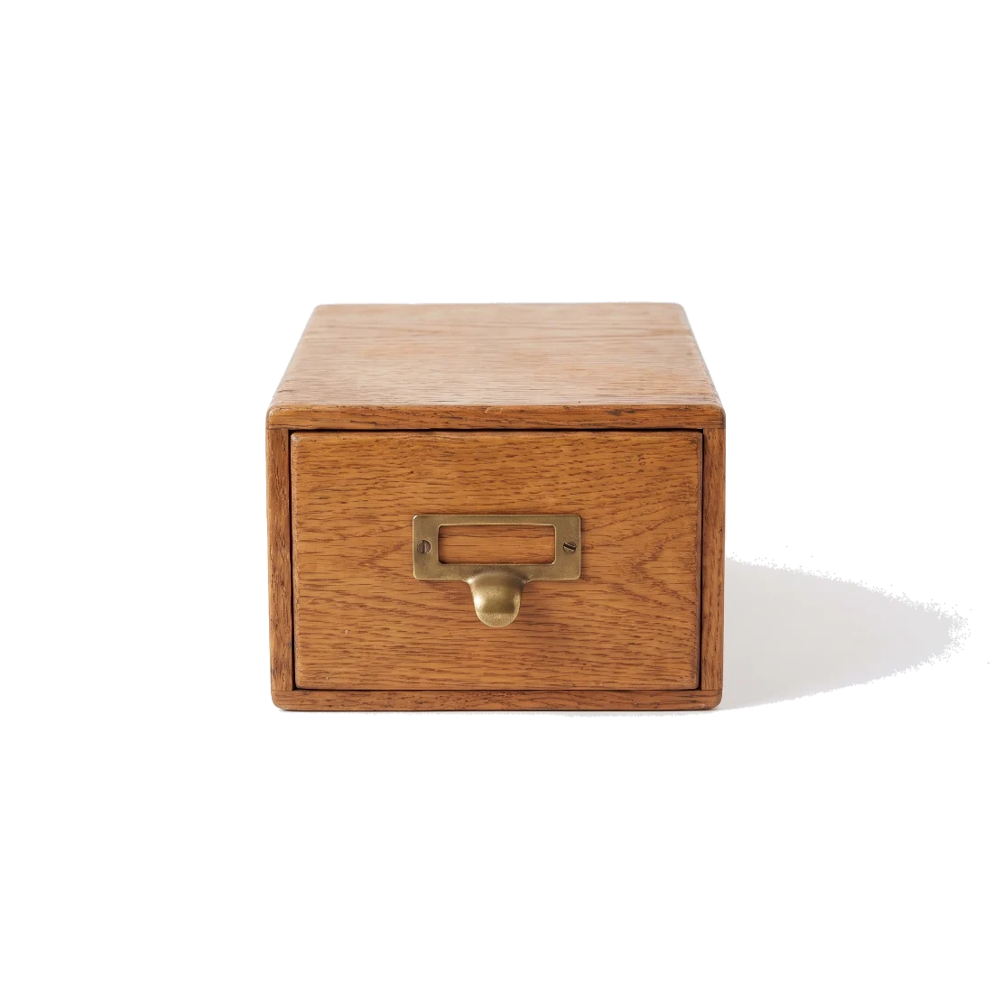 A closed oak card-file box with a brass pull.