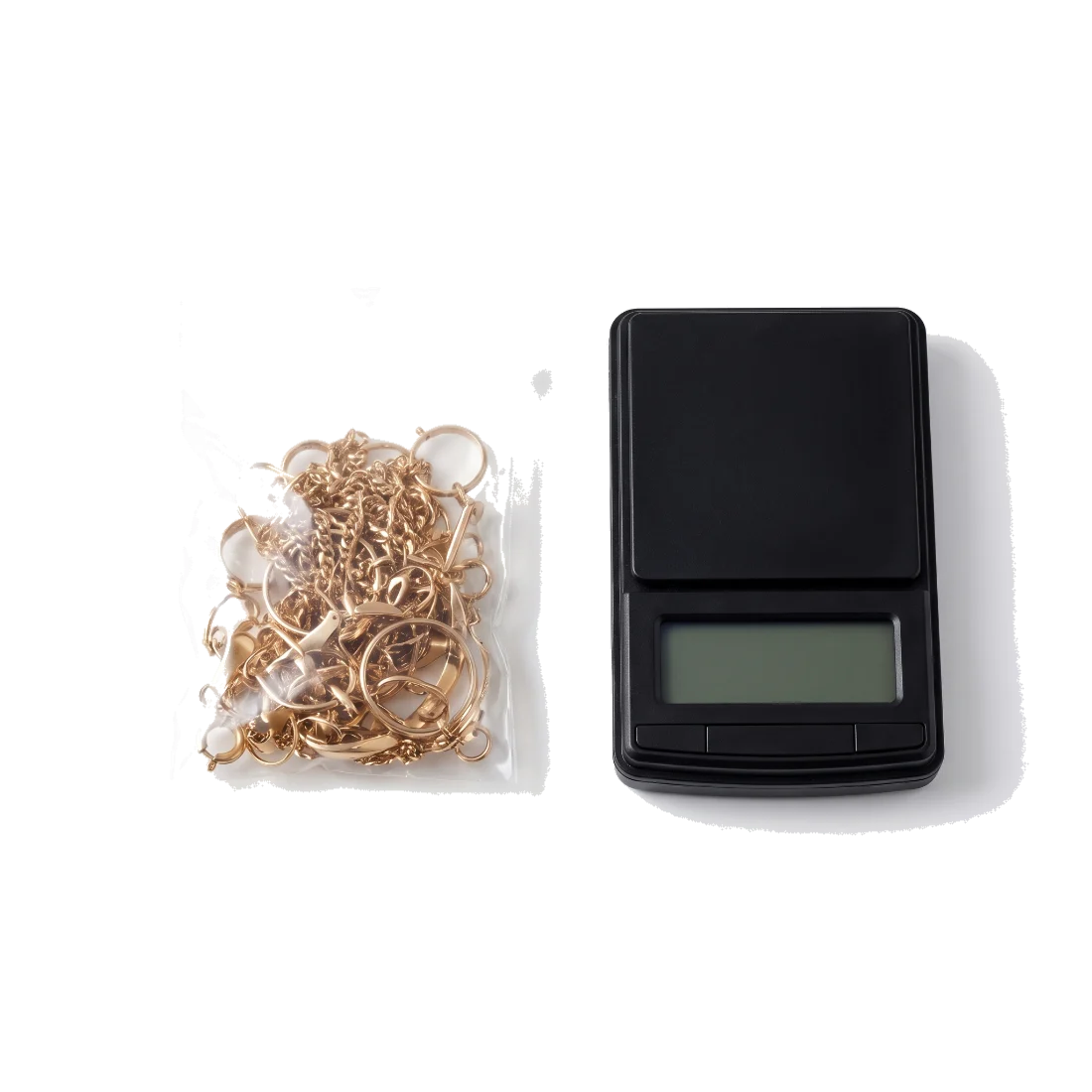 A small clear bag of mixed scrap gold beside a pocket scale.