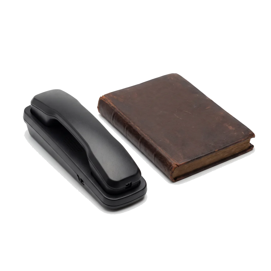 A black desk telephone handset on its cradle beside a closed, worn leather ledger.