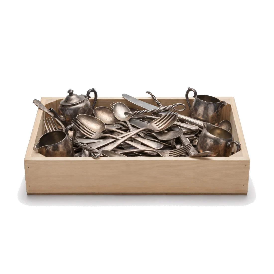 A shallow wooden crate heaped with tarnished silver flatware and scrap.